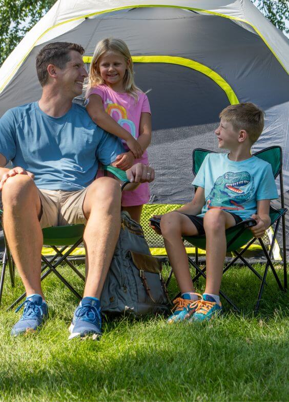 Man enjoying camping with his young son and daughter